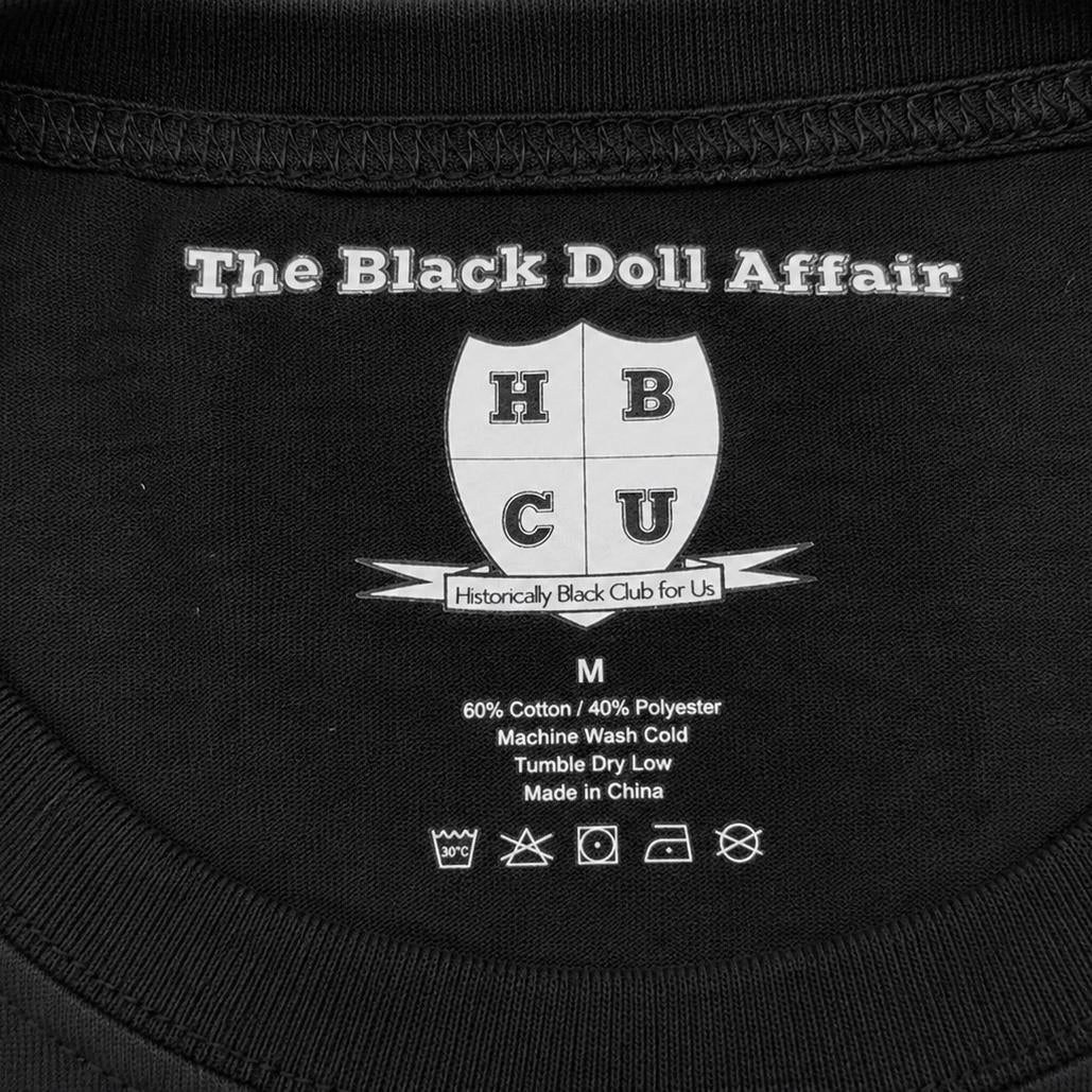 Black Doll Affair inside collar branding on black tagless top featuring HBCU logo and garment details. 