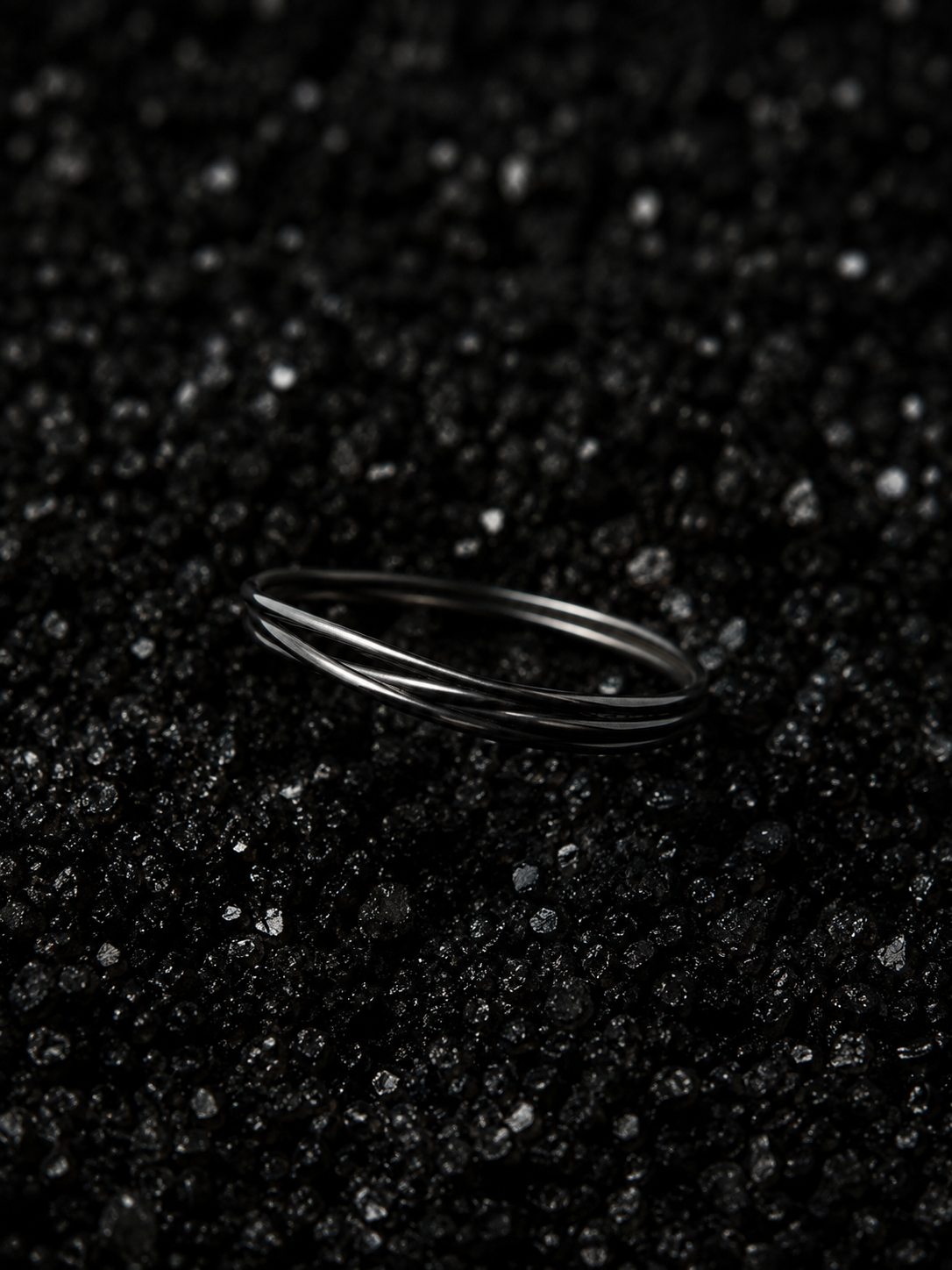 Black Forever Loop Adjustable Ring™ featuring a simple continuous wire design, created to sit between the gold and silver Unity Helix Rings™ as a symbol of unbroken, continuous DNA. 