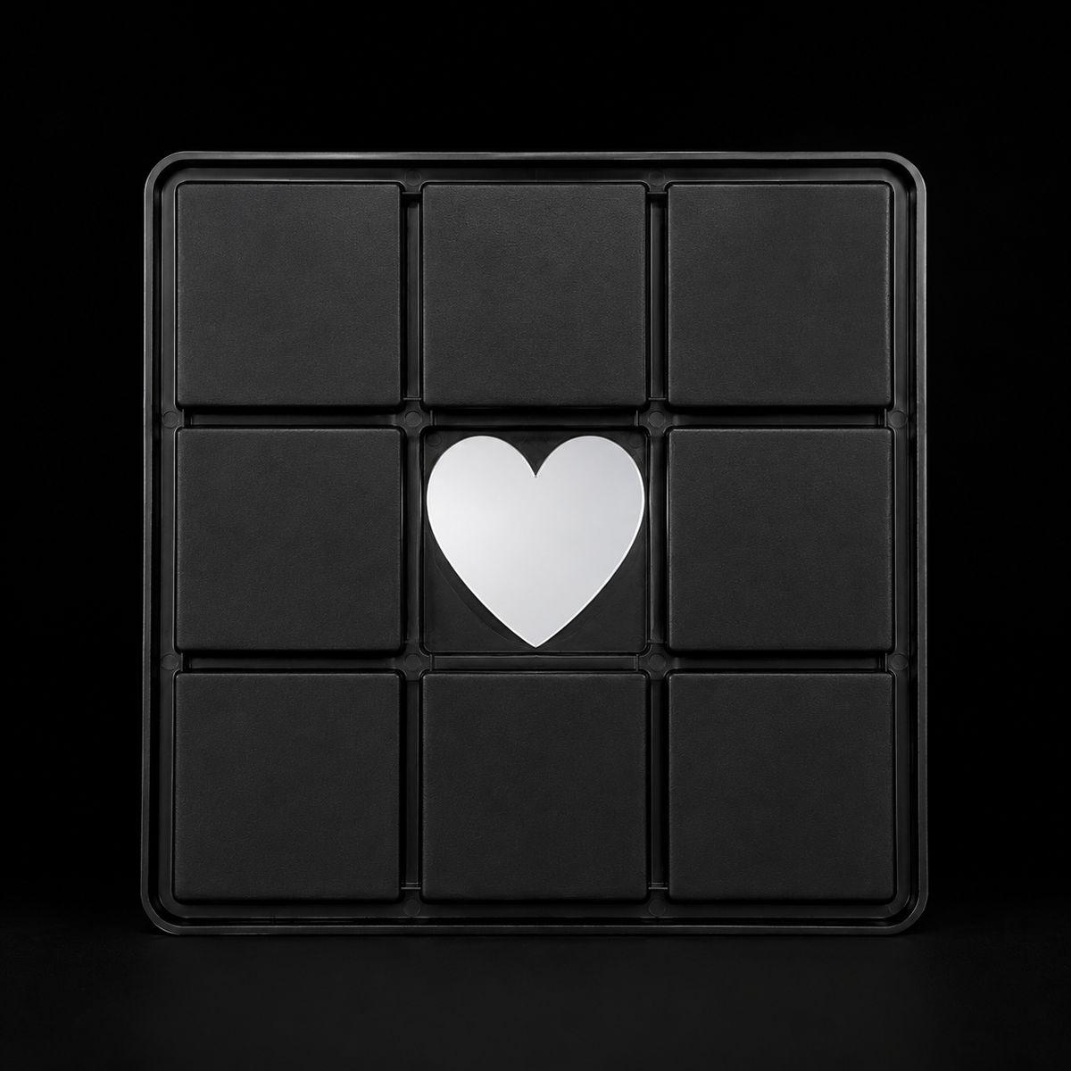 Bottom of the ME Doll-Tic-Tac-Toe game board featuring a centered silver heart on a black 3x3 grid 