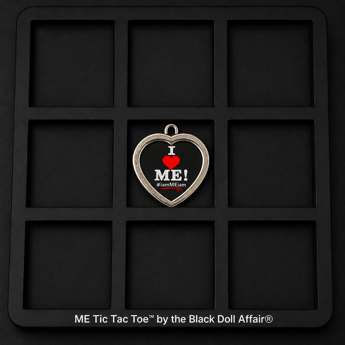 Empty ME Tic-Tac-Toe game board showing nine black squares and the heart-shaped I Love ME center piece.
