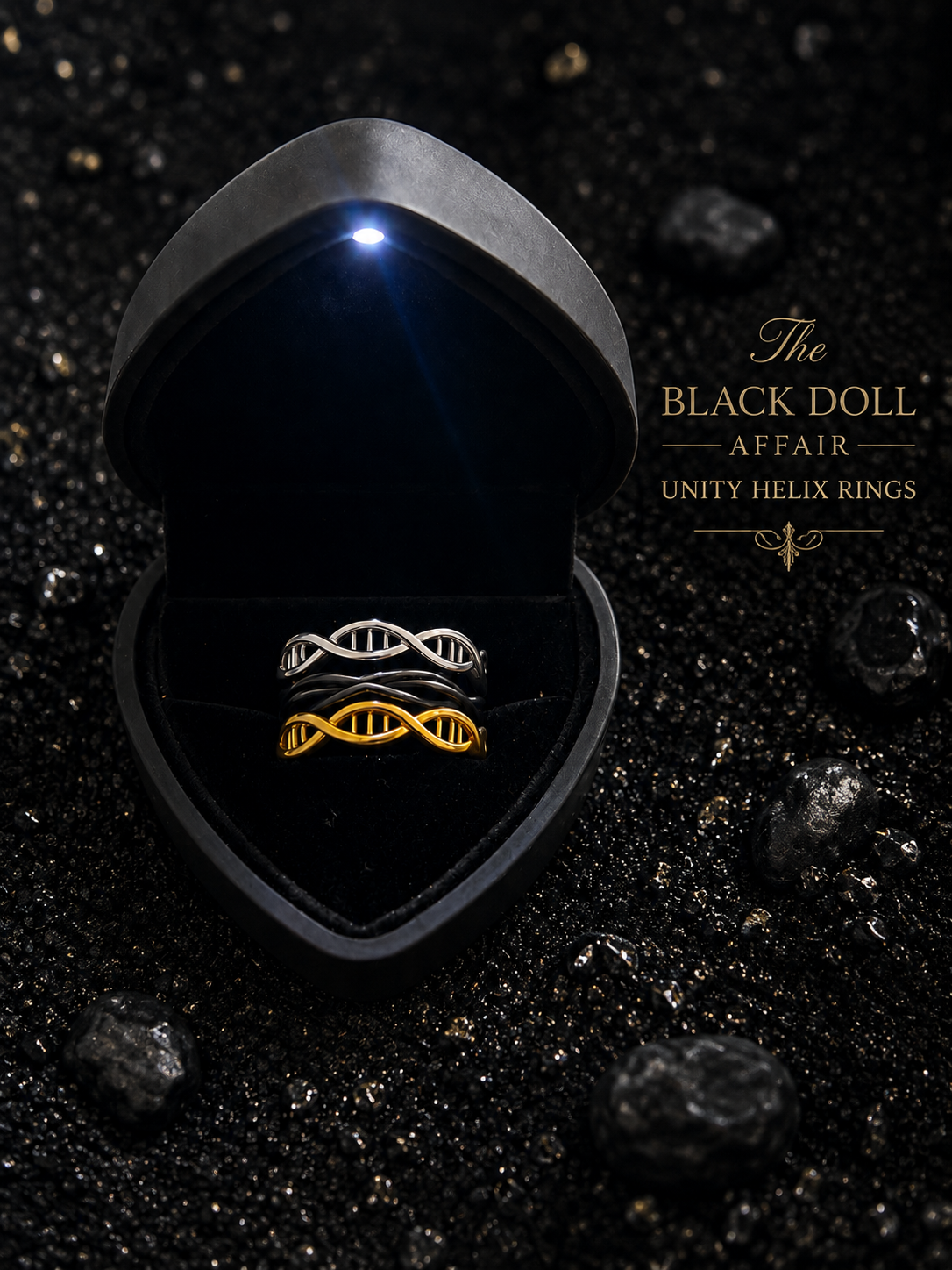 Three rings to make one. The Black Doll Affair Unity Helix Rings™ in black, silver and gold, are displayed inside a black heart-shaped LED jewelry box, black featuring a forever loop and the silver and gold each featuring a DNA double helix design. 